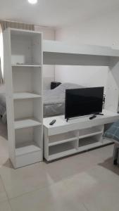 a white entertainment center with a tv on it in a bedroom at Monoambiente cómodo 4 pax in Necochea +15 photos