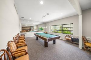 a game room with a pool table and chairs at Gulf and Bay Club- F401 in Siesta Key