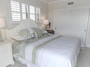 a white bedroom with a large bed and two windows at Gulf and Bay Club- F401 in Siesta Key +43 photos