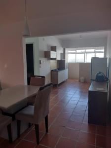 eine Küche und ein Esszimmer mit Tisch und Stühlen in der Unterkunft Apartamento temporada Guarujá in Guarujá