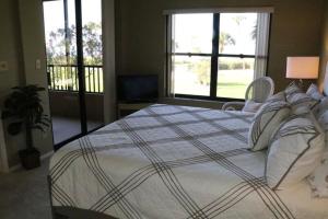 a bedroom with a large bed with pillows at Gulf and Bay Club- F105 in Siesta Key +51 photos