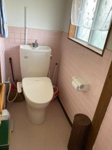 a pink bathroom with a toilet and a window at くりのやかた in Kunisaki +7 photos