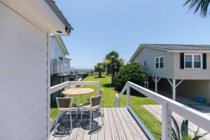 una terraza con mesa y sillas en una casa en Marysol Cottage, en Edisto Beach