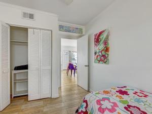 泰比岛Coops Retreat Unit B的卧室里有一张床，墙上挂着一幅画 更多11张照片