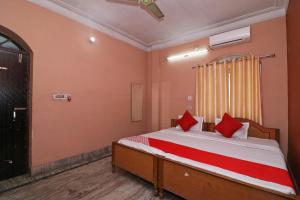 une chambre avec un lit avec des oreillers rouges dessus dans l'établissement Hotel O Sonora Hotel, à Dhanbād