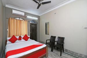 - une chambre avec un lit doté d'oreillers rouges et de 2 chaises dans l'établissement Hotel O Sonora Hotel, à Dhanbād