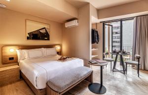 a hotel room with a bed and a balcony at Kukun Edition Marsella Juarez in Mexico City