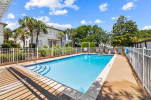 a swimming pool with a fence and trees at Happy Hour on 30A #5 by 30A Escapes in Seacrest