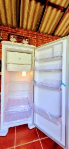 um frigorífico branco com a porta aberta num quarto em Pousada dos Chalés - Araras em Araras Petropolis