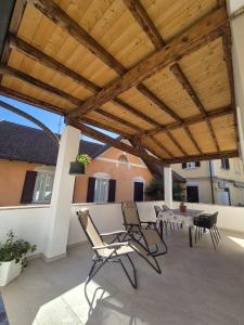 a patio with chairs and a table and a wooden roof at Il Glicine Bianco in Omegna