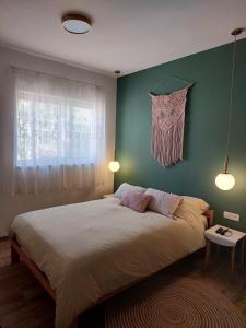 una camera da letto con un letto grande con una parete verde di בדרך לנחל a Sde Nehemia