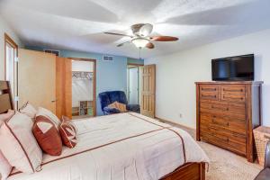 a bedroom with a bed and a flat screen tv at Work and Relax! Spacious Ontario Home with Pool in Mansfield