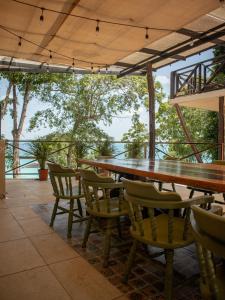 ein großer Holztisch und Stühle auf einer Terrasse in der Unterkunft Villas Mandarina Bacalar in Bacalar