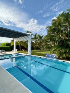 Espectacular Casa Campestre entre Giradot-Espinal في فلاندز: حمام سباحة كبير مع شرفة وأشجار نخيل