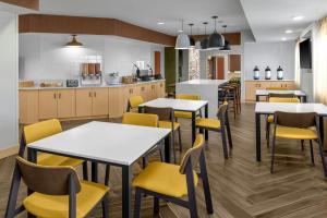 uma sala de jantar com mesas e cadeiras amarelas em Fairfield Inn & Suites Saginaw em Saginaw