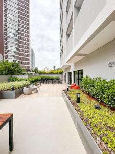 um pátio interno de um edifício com bancos e mesas em !Novinho! Apê Elamor - Brooklin - SP em São Paulo mais 20 fotografias