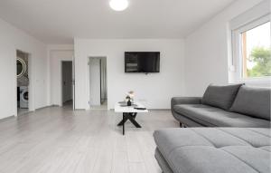 a white living room with a couch and a table at Nice Apartment In Vir With Heated Swimming Pool in Pedinka