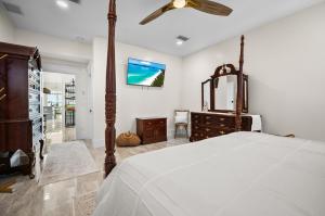 a bedroom with a bed and a dresser and a tv at Lemon Bay Luxe – Dock, Beach & Manasota Vibes in Punta Gorda Beach