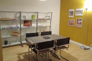 Zimmer mit Tisch, Stühlen und Regalen in der Unterkunft Le Petit Mouton in Pontorson + 10 Fotos