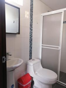 a white bathroom with a toilet and a sink at Privado y fascinante Apartaestudio San Alonso in Bucaramanga +19 photos
