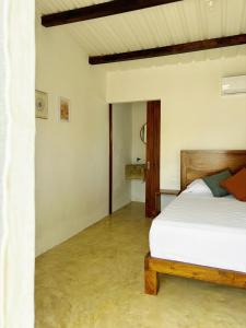 a bedroom with a white bed with a wooden frame at Buena Vista in El Paredón Buena Vista