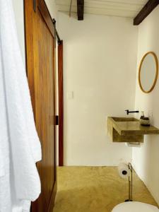 a bathroom with a toilet and a sink and a mirror at Buena Vista in El Paredón Buena Vista