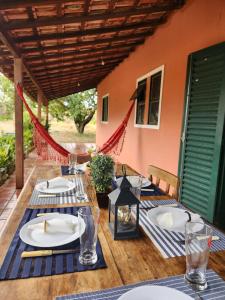 a wooden table with plates and glasses on it at Refúgio com Piscina, Churrasco e Lazer no Campo in Sumaré