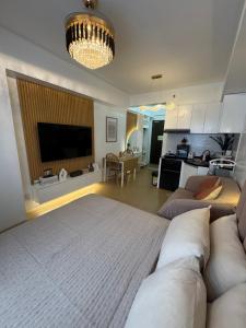 a bedroom with a large bed and a living room at CDO Nest in Cagayan de Oro