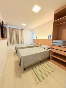 Un dormitorio con dos camas y un televisor. en Cobertura com Piscina Privativa em Resort Pé na Areia, en Arraial do Cabo 103 fotos más