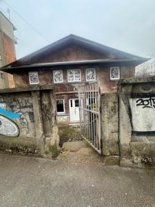 a building with a gate and graffiti on it at Botanical garden in Zagreb