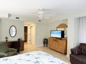 a living room with a flat screen tv and a couch at Stylish Gulf Condo - Walk to Beach, Pool & Dining in Punta Gorda Beach