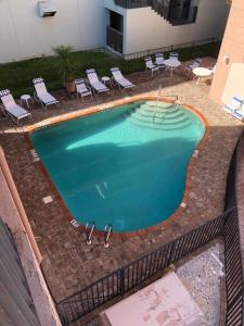an empty swimming pool with chairs at Stylish Gulf Condo - Walk to Beach, Pool & Dining in Punta Gorda Beach