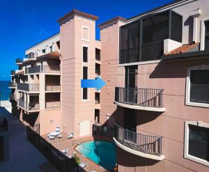 a view of a building with balconies and a pool at Stylish Gulf Condo - Walk to Beach, Pool & Dining in Punta Gorda Beach