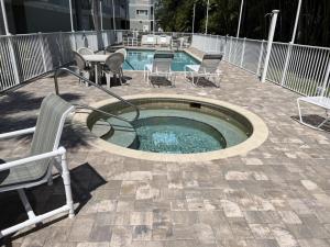 a small pool with chairs and a table and a bench at Manasota Key Gem - Pool and Hot Tub - Beach Views in Punta Gorda Beach