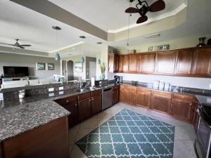a large kitchen with wooden cabinets and a blue rug at Manasota Key Gem - Pool and Hot Tub - Beach Views in Punta Gorda Beach