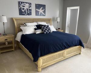 a bedroom with a large bed with blue and white pillows at Manasota Key Gem - Pool and Hot Tub - Beach Views in Punta Gorda Beach +26 photos