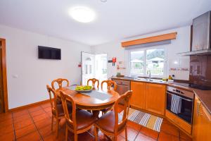 a kitchen with a table and chairs in a kitchen at Casa do Cantinho do Muro in São Vicente
