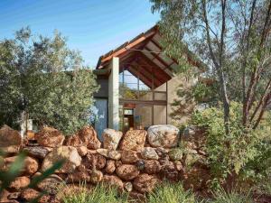 a house with a rock wall in front of it at Pullman Bunker Bay Resort Margaret River in Dunsborough