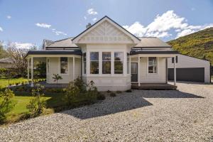 a white house with a gravel driveway at The 1909 Gables Villa in Arrowtown