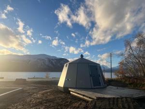 a tent sitting on a dock next to a body of water at Northern Lights AuroraHut Lyngenfjord, by Alpan Apartments in Olderdalen