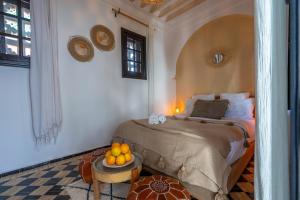 a bedroom with a bed and a table with oranges on it at Riad NL&S Collection in Marrakech +84 photos