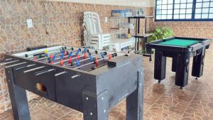 a large black foosball table and pool table at Nova Aliança Suítes por Temporada em Amparo NÃO SOMOS POUSADA in Amparo +11 photos