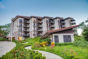 an apartment building with a garden in front of it at A10- Roble Sabana 201 in Playa Conchal