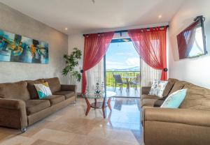 a living room with two couches and a glass table at A10- Roble Sabana 201 in Playa Conchal