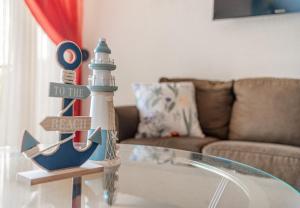 a glass coffee table with a figurine of a lighthouse at A10- Roble Sabana 201 in Playa Conchal