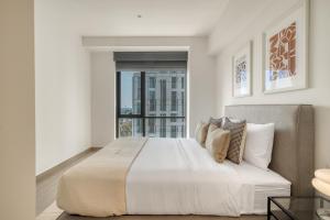 ein weißes Schlafzimmer mit einem großen Bett und einem Fenster in der Unterkunft Nido at Gran Ciudad Nuevo Polanco in Mexiko-Stadt