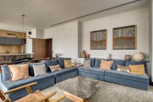 ein Wohnzimmer mit einer blauen Couch mit Kissen in der Unterkunft Nido at Gran Ciudad Nuevo Polanco in Mexiko-Stadt