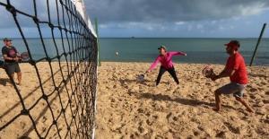a group of people playing volleyball on the beach at Aconchego Floripa Vista Mar in Florianópolis