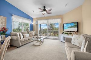Una sala de estar con un sofá y un televisor en Gulf Sands – 3BR Steps to Pool & Private Beach, en Punta Gorda Beach