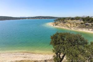 ein großes Gewässer mit einem Baum im Vordergrund in der Unterkunft Waterfront Family Oasis Spa Firepit Outdoor Kitchen in Canyon Lake